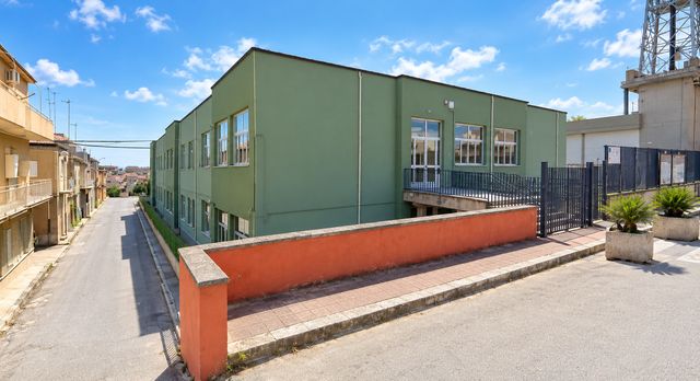 Il plesso Vittorini in Via Bruno Buozzi a Ravanusa: edificio verde su due piani con la rampa d'accesso e il cancello